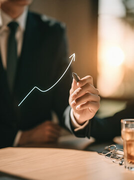 Business executive drawing glowing upward curve on glass panel during sunset, expressing confidence, strategy, growth, and financial success