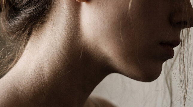 Profile silhouette of female jawline chin and neck in low light