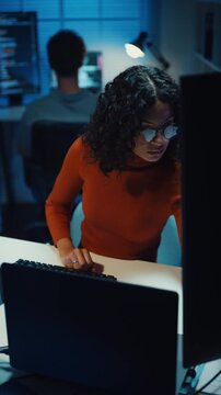 Vertical Screen : Group Adult male, female freelance typing write prompt AI bot IT app smart program nomad, video game, terminal with coding language, data center on desktop computer in office night.