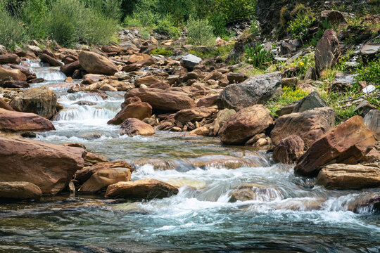 Senderismo por los Pirineos en el Valle de Aran. Caminando junto al r&iacute;o con peque&ntilde;as cascadas de agua