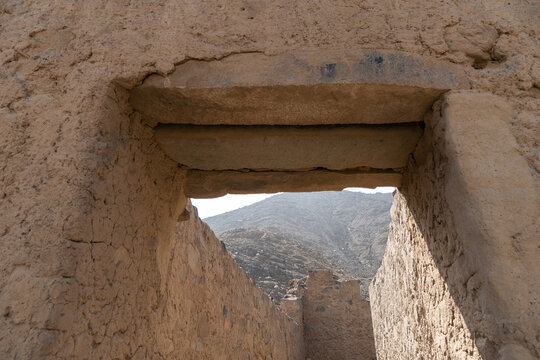 Ancient trapezoidal adobe door with stone lintel and steps at the Huayc&aacute;n de Cieneguilla archaeological site, Peru.