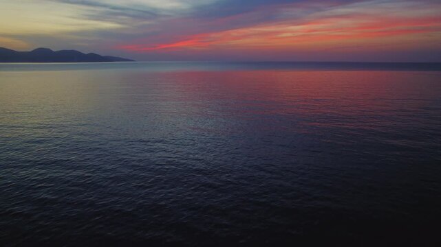 Colorful sunset sky reflecting on calm open sea during peaceful evening hour