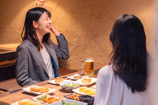 居酒屋でお酒を飲む女性の会社員
