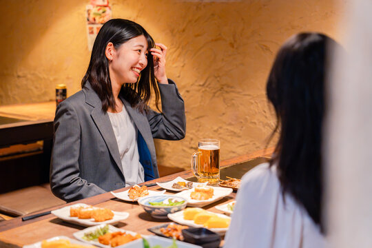 居酒屋でお酒を飲む女性の会社員