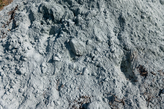 Close-up texture of pulverized agricultural lime with powder and clumps, a mineral soil amendment used for liming, acidity correction and pH management in agriculture.
