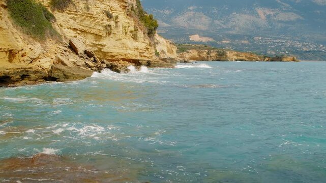 Cliffside coastline with waves and mountains in summer Kefalonia island, Greece