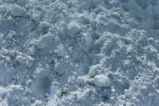 Close-up texture of pulverized agricultural lime with powder and clumps, a mineral soil amendment used for liming, acidity correction and pH management in agriculture.
