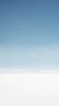 Falling blue flower petals drift gently against a bright clear sky in this peaceful slow motion abstract video animation clip