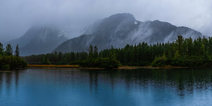 Panoramic Alaska autumn landscape at Moose Flat Lake on a foggy rainy day in Girdwood south of Anchorage, USA
