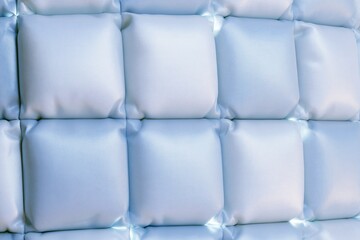 Obraz premium Close up view of padded tufted light blue square puffy quilted wall panel for modern bedroom interior upholstery design decoration