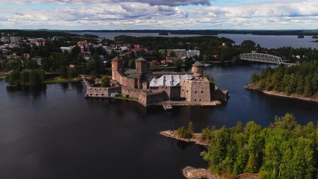 Aerial view rotating away from the Olavinlinna castle in sunny Savonlinna, Finland