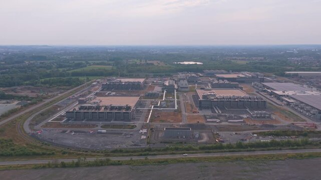Expansive aerial view of a modern hyperscale data center during its construction phase. The large complex is crucial for cloud computing services