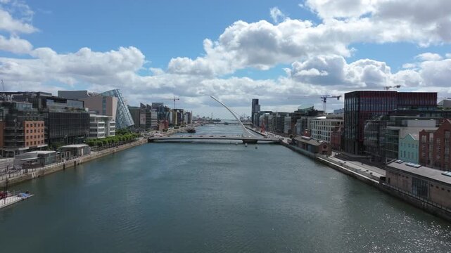 Modern office blocks and the Samuel Beckett Bridge line the River Liffey as a drone slowly advances through Dublin&rsquo;s docklands on a bright summer day.