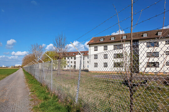 Heidelberg, Germany -  Abandoned buildings in Patrick-Henry-Village Heidelberg behind barbed wire fence. Former US military housing area marked off as restricted redevelopment site