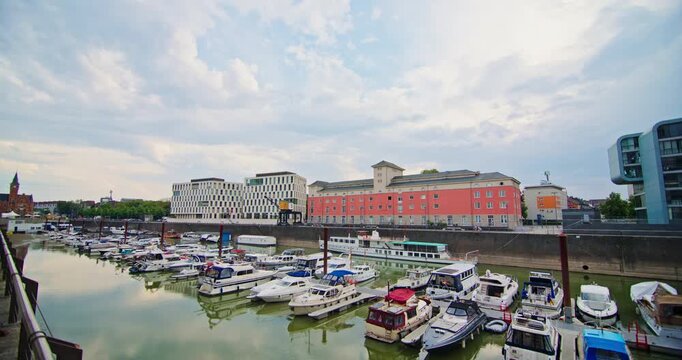 Beautiful moored boats on Cologne Rhine docks surrounded by modern urban architecture scenic waterfront views and famous tourist locations in Europe 