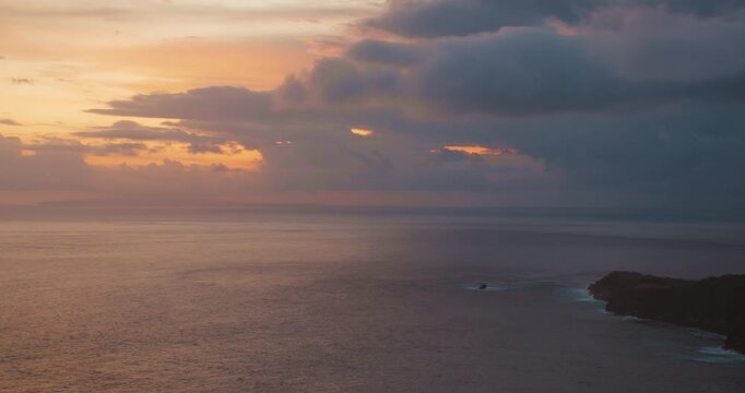 Sunset clouds float over calm ocean horizon in Bali Nusa Penida Indonesia