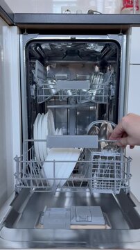 kitchen appliances. Men's hands check the cleanliness of the dishes