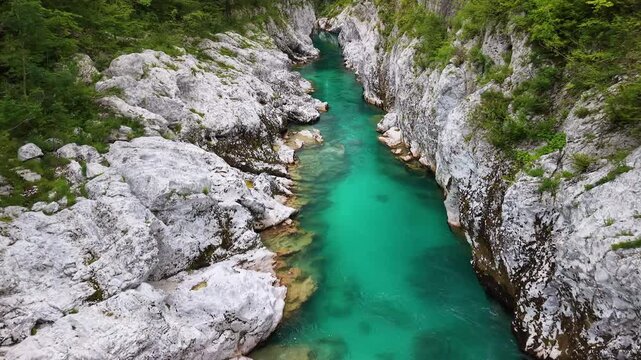 Aerial drone view of the narrow gorge where the emerald river cuts through smooth white rock, Soca Valley, Slovenia