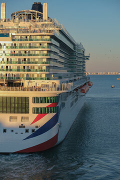 Massive gigantic modern cruiseship cruise ship liner Iona or Arvia in Cadiz, Spain during summer Mediterranean cruising with harbor and container port infrastructure