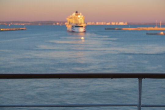 Massive gigantic modern cruiseship cruise ship liner Iona or Arvia in Cadiz, Spain during summer Mediterranean cruising with harbor and container port infrastructure