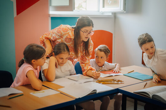 Teacher mentoring primary school students in classroom learning environment