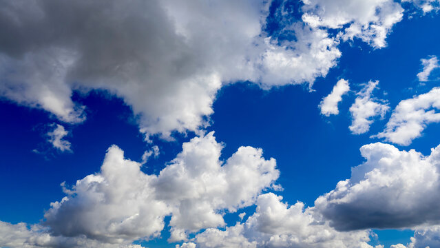 fluffy white and gray clouds in bright blue sky