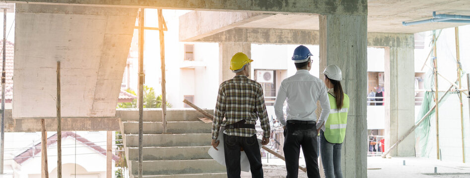 Asian contractor and engineer inspecting material in construction building.
