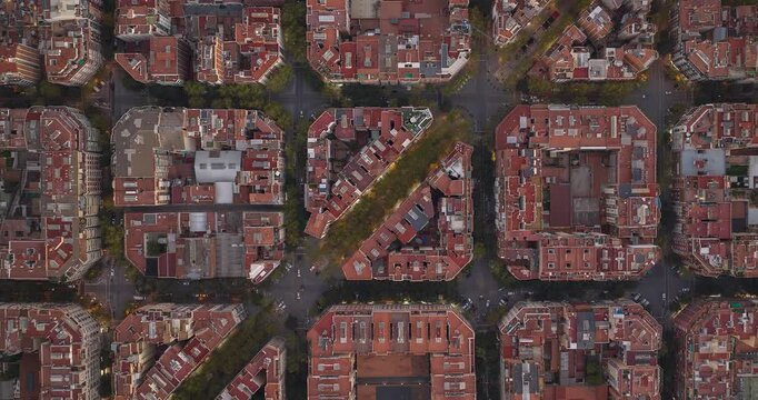 Aerial birds eye view of rectangular red roof buildings architecture cityscape and traffic in Barcelona. Drone hyper lapse shot over Eixample residential famous urban streets grid of  Catalonia, Spain