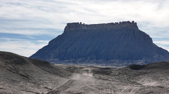 Drone Shot of ATV Vehicle Making Dust on the Way to Factory Butte, Utah USA