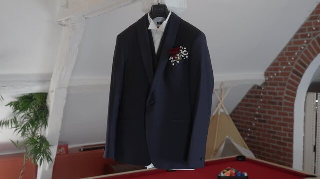 Slow rightward pan shows a groom suit with boutonniere above a red pool table