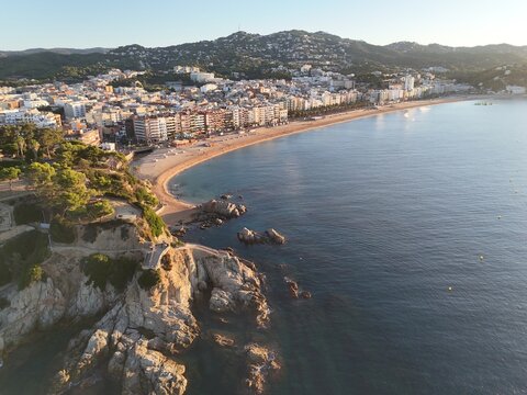 Aerial view taken from a drone of the coast of Lloret de Mar, Costa Brava, Spain, early in the morning at sunrise - the sea, beach and coastal hotels