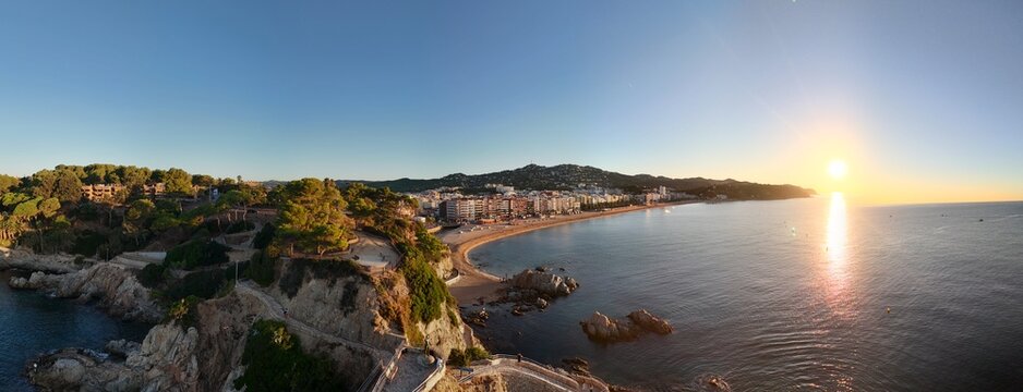 Aerial view taken from a drone of the coast of Lloret de Mar, Costa Brava, Spain, early in the morning at sunrise - the sea, beach and coastal hotels