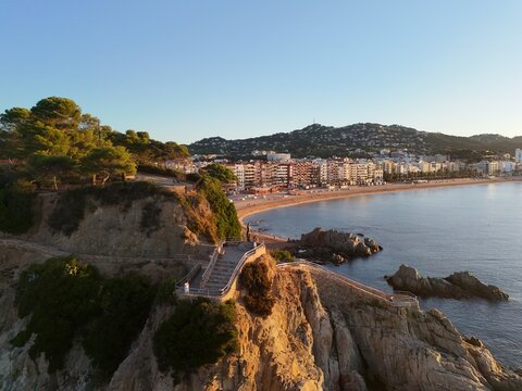 Aerial view taken from a drone of the coast of Lloret de Mar, Costa Brava, Spain, early in the morning at sunrise - the sea, beach and coastal hotels