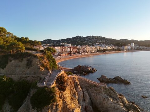 Aerial view taken from a drone of the coast of Lloret de Mar, Costa Brava, Spain, early in the morning at sunrise - the sea, beach and coastal hotels