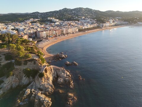 Aerial view taken from a drone of the coast of Lloret de Mar, Costa Brava, Spain, early in the morning at sunrise - the sea, beach and coastal hotels