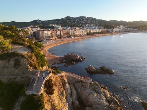 Aerial view taken from a drone of the coast of Lloret de Mar, Costa Brava, Spain, early in the morning at sunrise - the sea, beach and coastal hotels