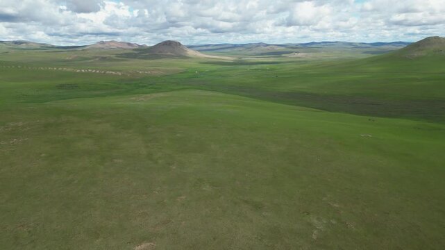 Sweeping aerial panorama of rolling green Mongolian steppe, copy space