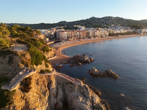 Aerial view taken from a drone of the coast of Lloret de Mar, Costa Brava, Spain, early in the morning at sunrise - the sea, beach and coastal hotels