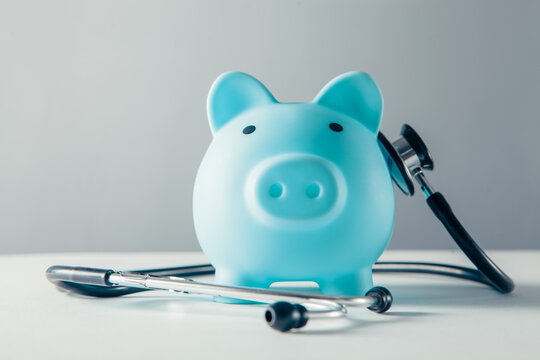 Piggy bank with stethoscope on grey background. Health care concept