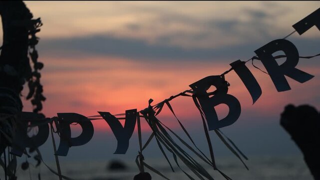 Happy Birthday Banner Hanging on a Beach Tree at Sunset, close up