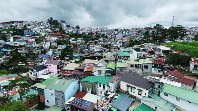 Aerial view of densely packed residential area with colorful roofs on cloudy day