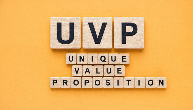 Uvp unique value proposition concept spelled out with wooden letter tiles on orange background
