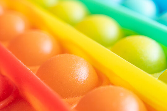 Close-up of the popular children toy pop It fidget with soft focus. Macro. New popular silicone colorful pop It game. Anti-stress