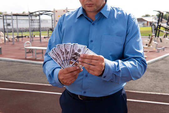money laundering on the construction of stadiums and sports grounds concept. Businessman has money in his hand stadium background