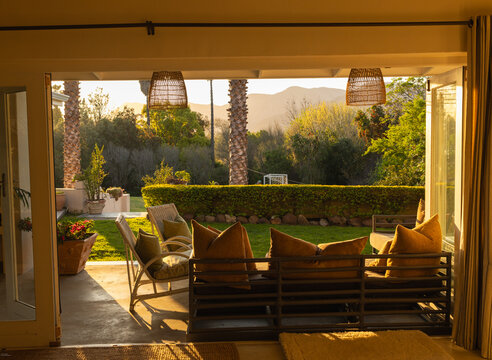 elderly man in beautiful outdoor patio overlooking vast garden and mountains at sunset
