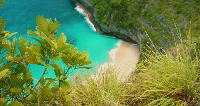 Top view of ocean waves meeting sand at Kelingking Beach on Nusa Penida Bali