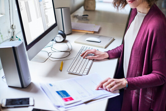 Hands, woman and computer in office with document, news feature and manuscript headline for story. Editor, reading or pc screen in workplace with paperwork, interview questions and article submission