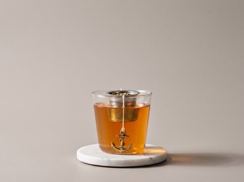 Glass cup of herbal tea with an anchor shaped tea infuser