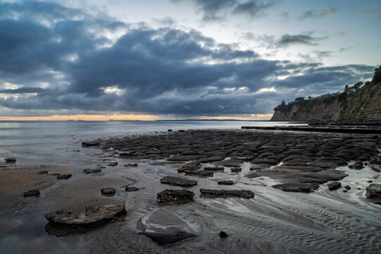 Dramatic sunrise capture at Long Bay beach, Auckland, New Zealand