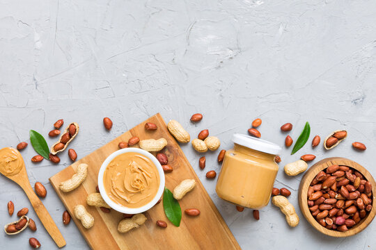 Bowl of peanut butter and peanuts on table background. top view with copy space. Creamy peanut pasta in small bowl
